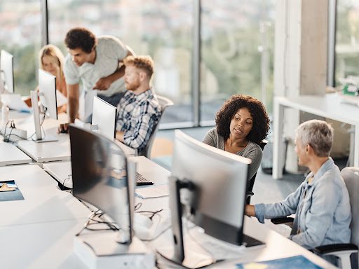 team of four in an office working together on a solution