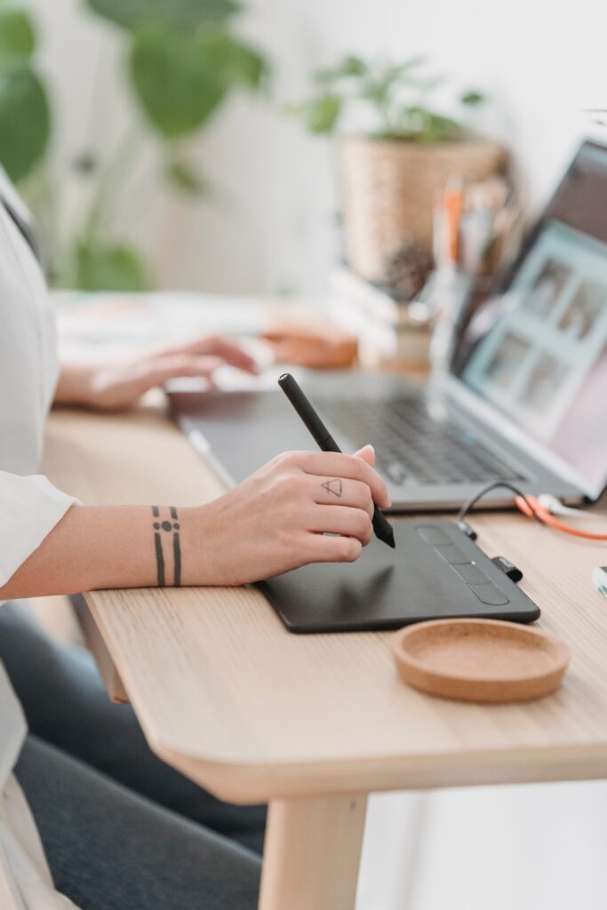 Woman's hands use drawing tablet and laptop