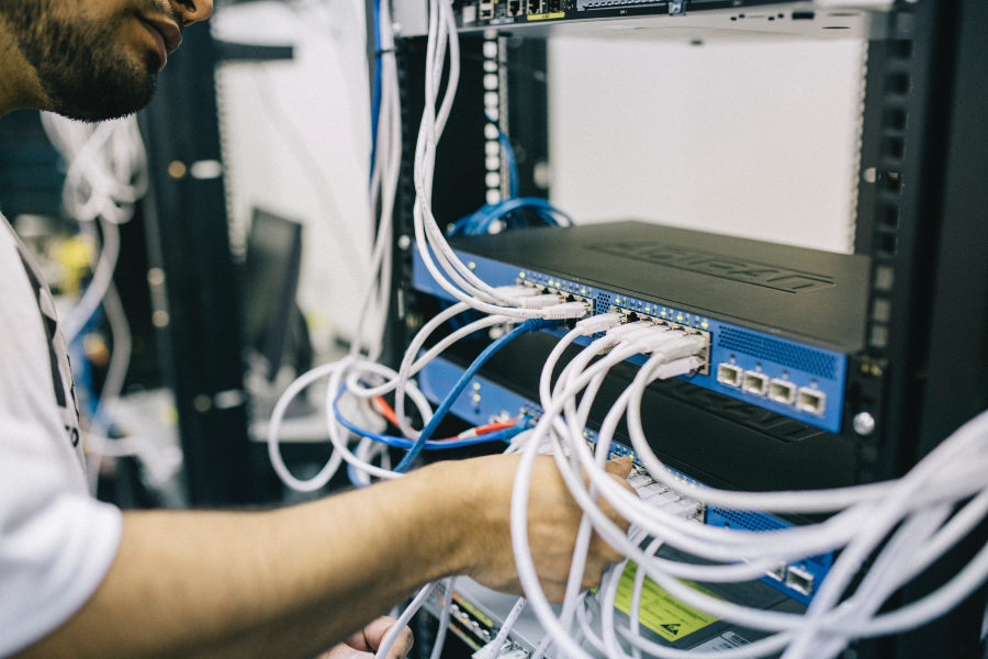 Person working on servers on a server rack.